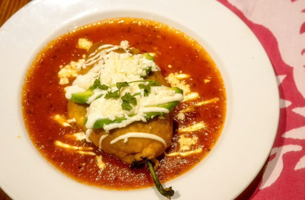 White plate with mexican stuffed chili chile relleno and copyspace