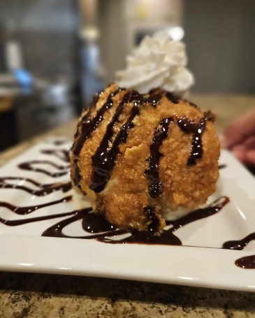 Dessert: "A beautifully presented dessert of churros served with a side of rich chocolate sauce."