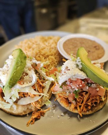 Authentic Mexican Meal: "An authentic Mexican meal featuring enchiladas, rice, beans, and a side of fresh guacamole."