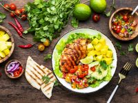 Grilled chicken salad with avocado, mango, tomato salsa, cilantro and lettuce in mexican style