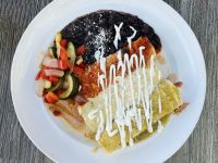 Overhead view of enchiladas, beans and vegetables