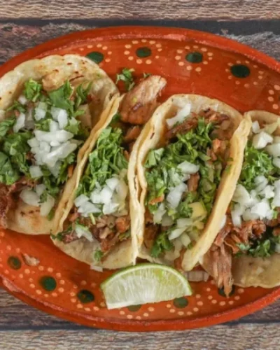 Street Tacos: "A plate of authentic street tacos filled with tender, marinated meat, topped with fresh cilantro and onions, served with lime wedges on the side."